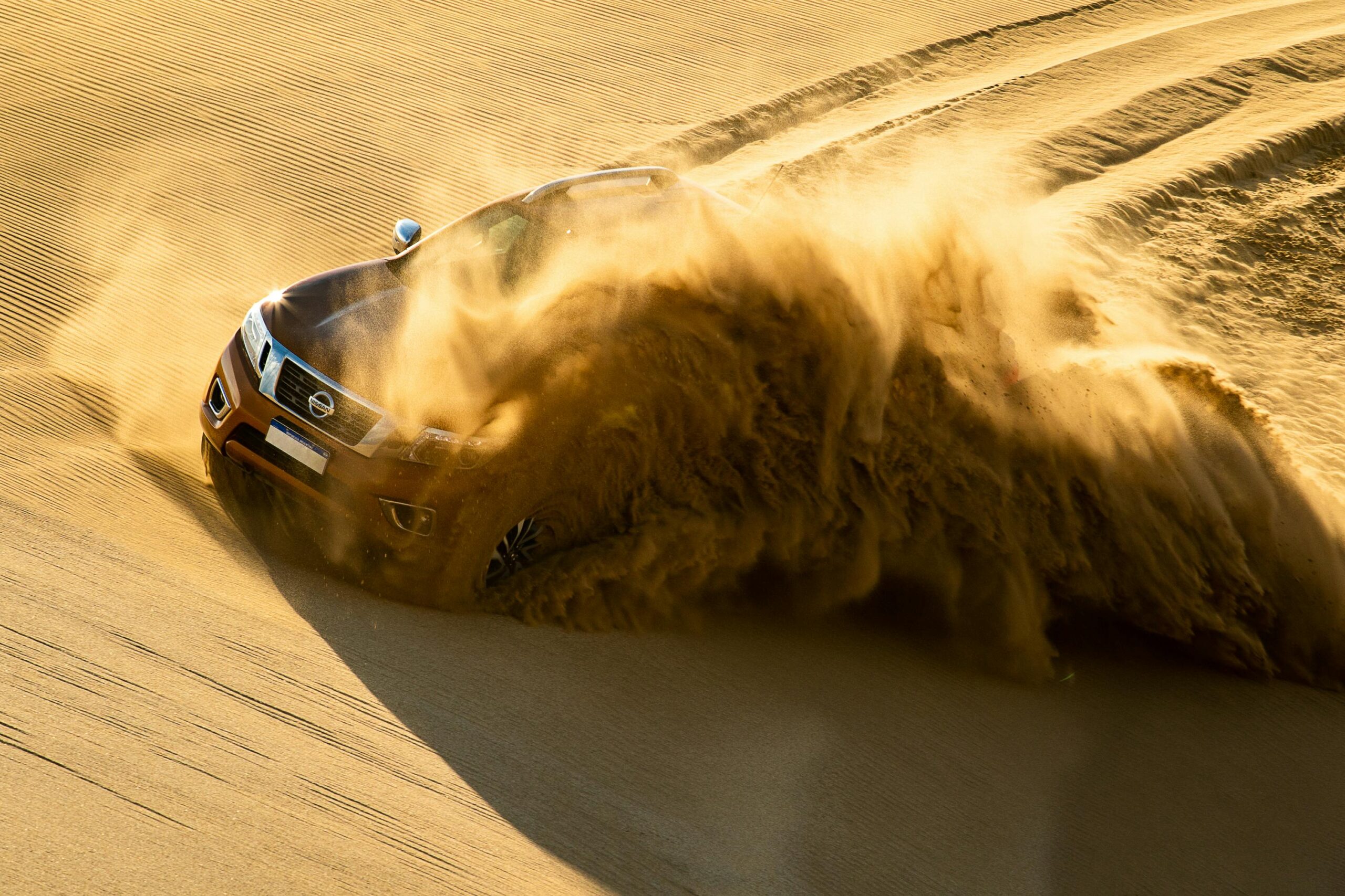 pexels-photo-1370746-1370746 Dynamic shot of an SUV kicking up sand as it speeds through dunes in CarilĂł, Argentina.