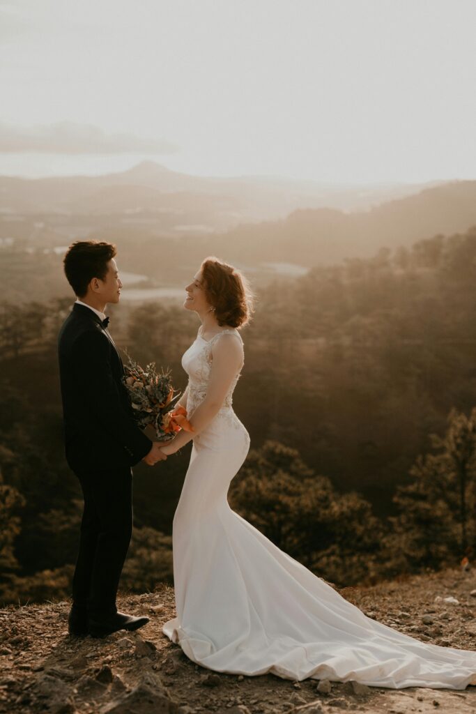 A couple stands in a picturesque location, celebrating their wedding at sunrise in Dalat, Vietnam.