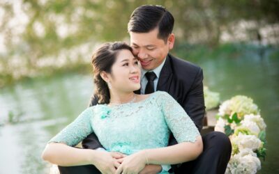 A joyful Asian couple enjoying an engagement moment in a beautiful garden.