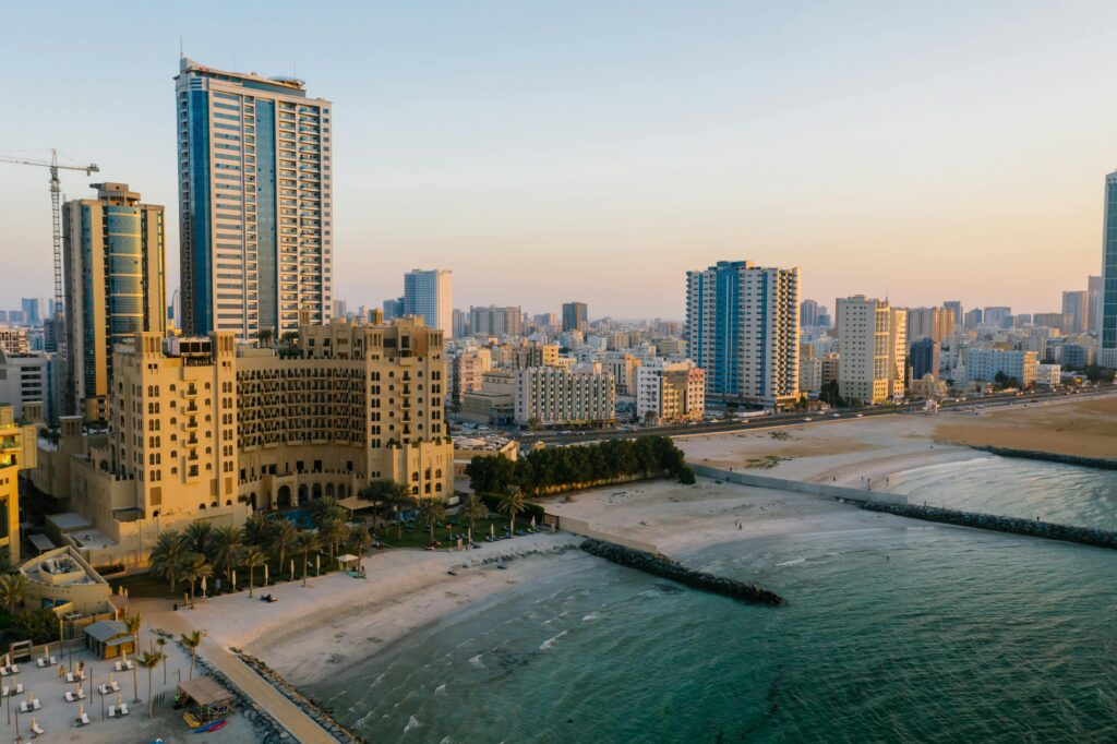 pexels-photo-8319453-8319453 Explore the stunning aerial view of Ajman's urban coastal landscape, captured at sunset.