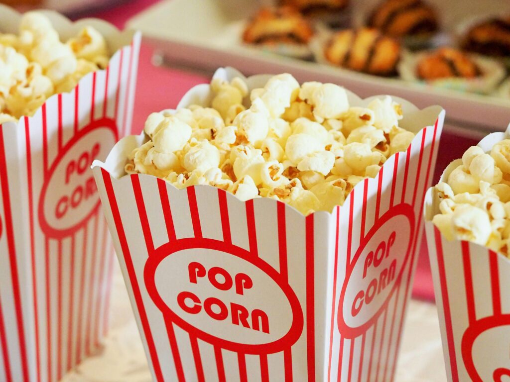 popcorn-movie-party-entertainment-33129 Close-up of gourmet popcorn in classic red and white striped boxes, perfect cinema snack.