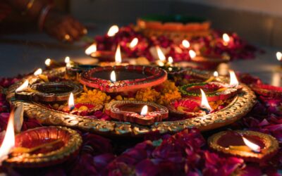 Beautifully lit traditional oil lamps (diyas) decorated with marigold flowers, celebrating Diwali in Jaipur, India.