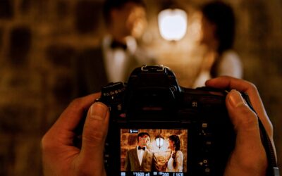 A romantic couple captured through a camera screen with warm lighting indoors.