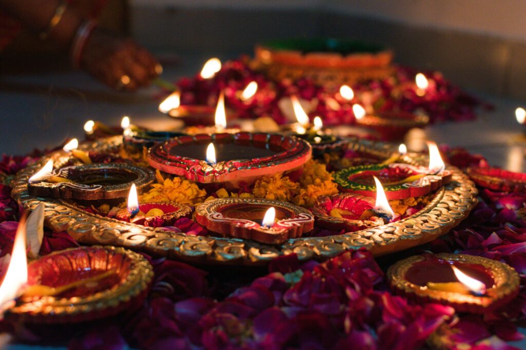 Beautifully lit traditional oil lamps (diyas) decorated with marigold flowers, celebrating Diwali in Jaipur, India.